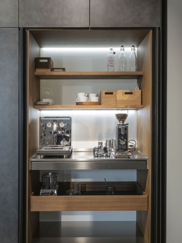 Ein Schrank mit Küchengeräte, z.B. einer Kaffeemaschine und einer Kaffeemühle