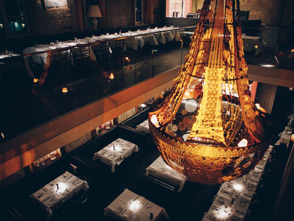 Ein Kronenleuchter erhellt über 2 Stockwerke verteilte Restaurant-Tische